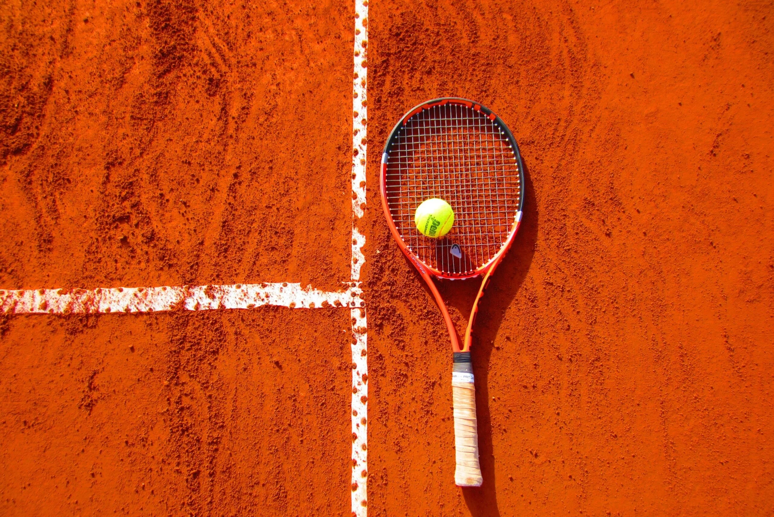 clay tennis court and racket